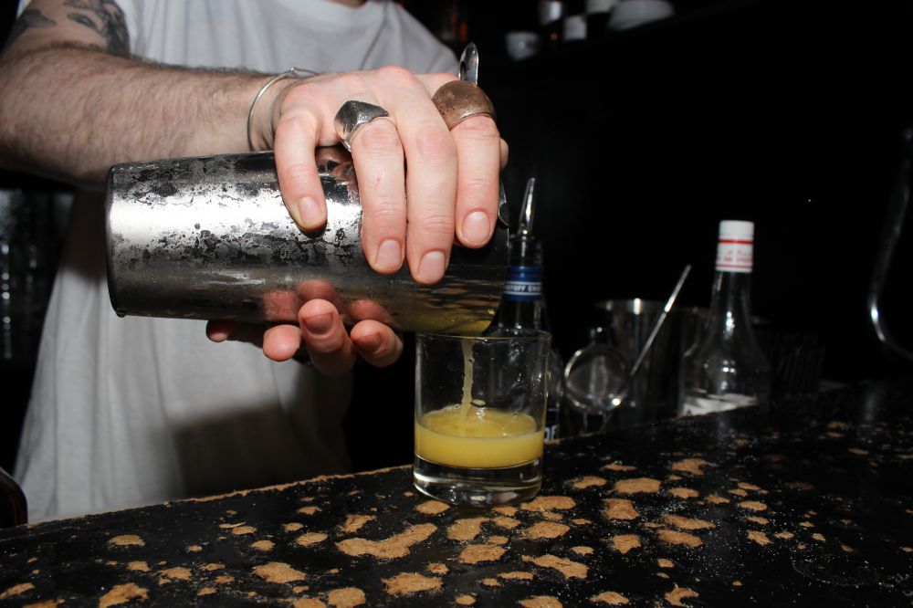Une fois la vodka ajoutée et le tout bien shaké, verser la mixture dans un verre à whisky à l'aide d'une passoire