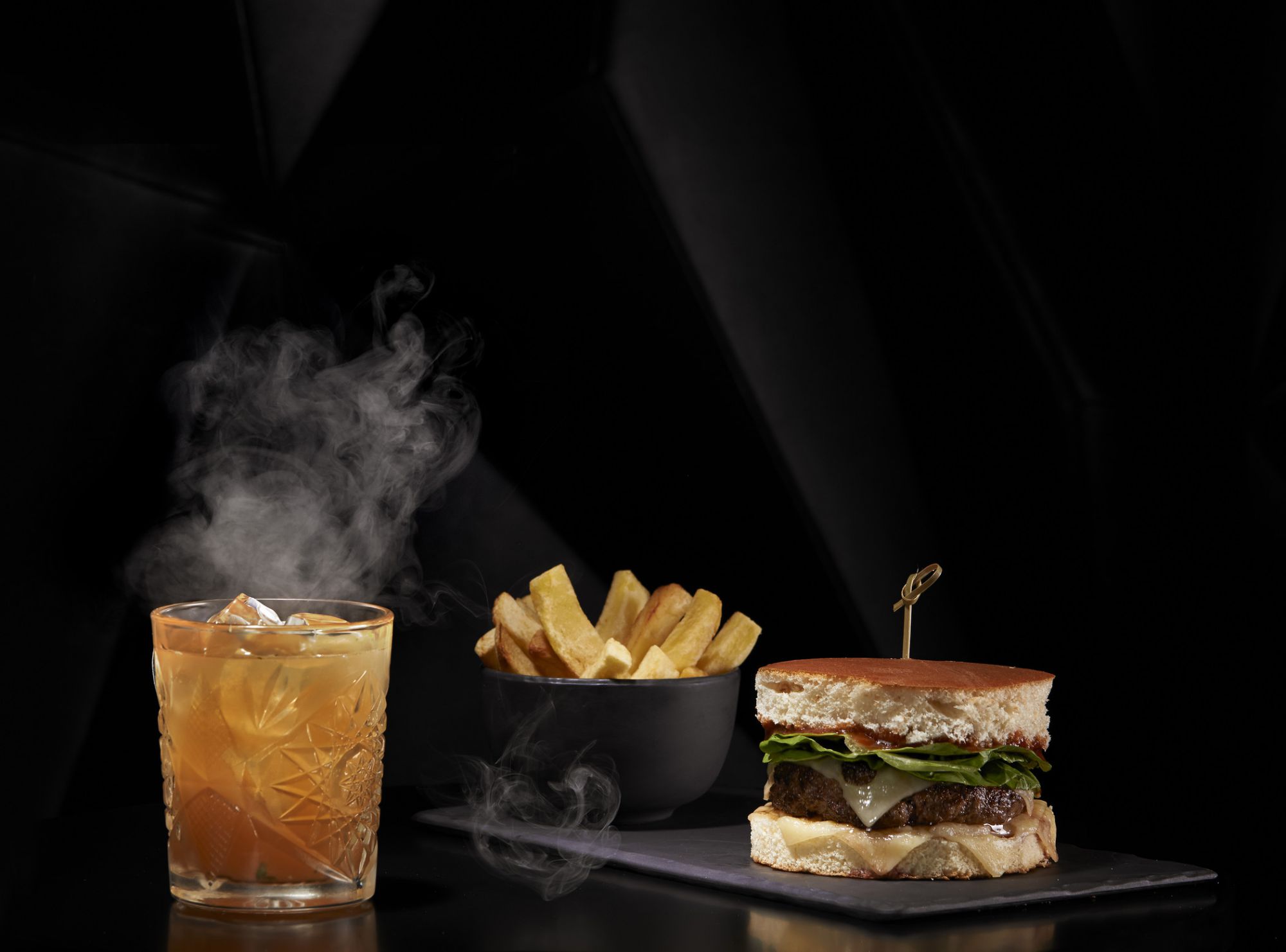 Le Brûlé, le cocktail signature du bar et le burger du restaurant Coquette avec sa viande macérée au whisky