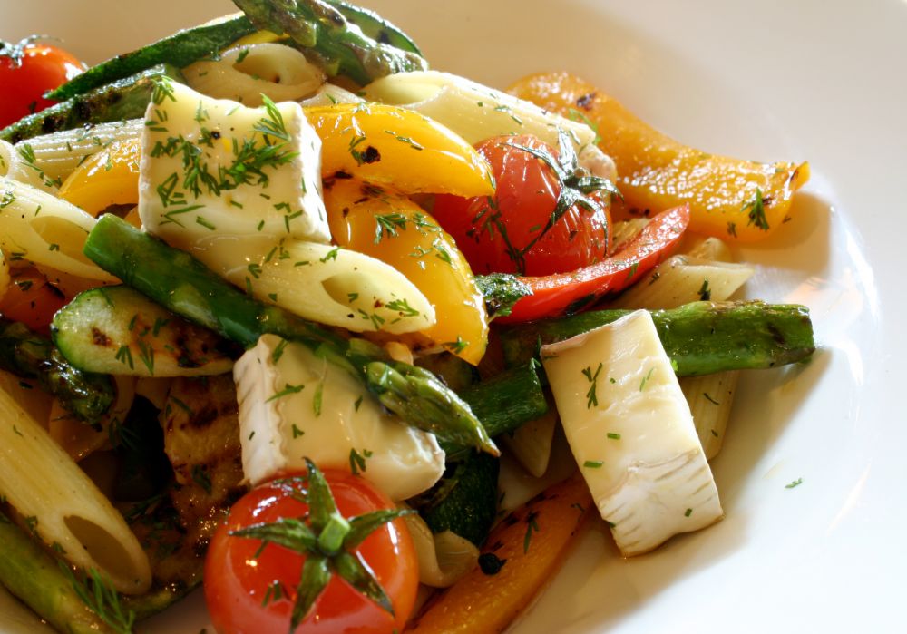 Salade de pennes, tofu et de légumes assaisonnés à l'huile d'olive.